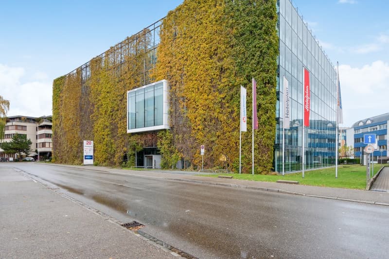 Modern glass and steel structure with a vertical garden covering a large section of the building.