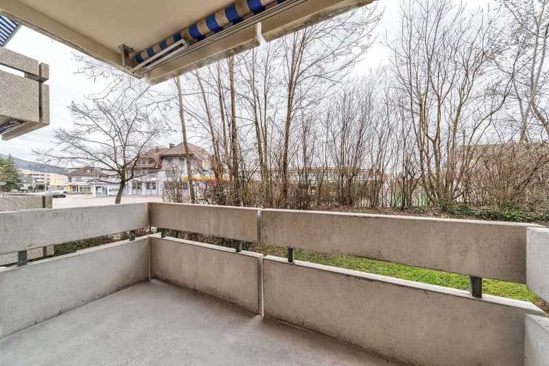 Concrete balcony, fenced with concrete walls, metal railings, concrete awning