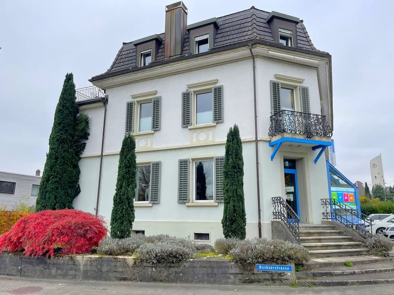 white building, 3 stories, multiple windows, balcony on second floor, entrance stairs