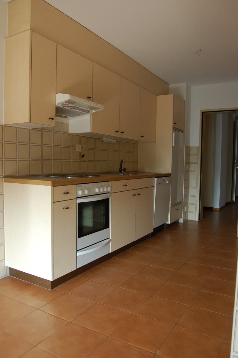 white appliances, tiled countertop, tiled floor, cabinet and drawer units, wall-mounted power outlet