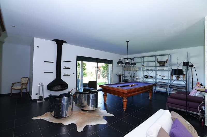 pool table, fireplace, metal chairs, rug, shelves, lamps