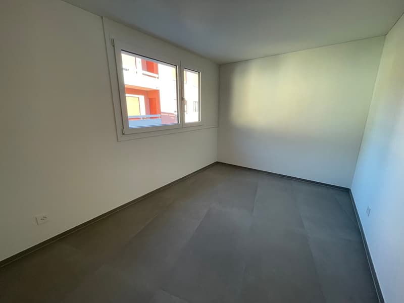 empty room with window, grey floor, white walls