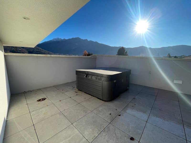 large outdoor area with tiled floor and hot tub