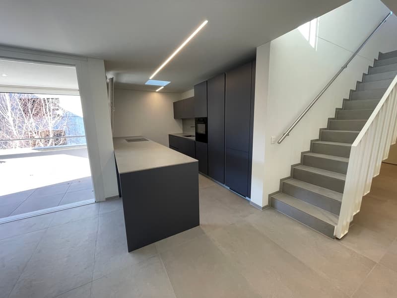 Open kitchen with kitchen island, modern built-in wardrobes, large window with glass door leading to balcony