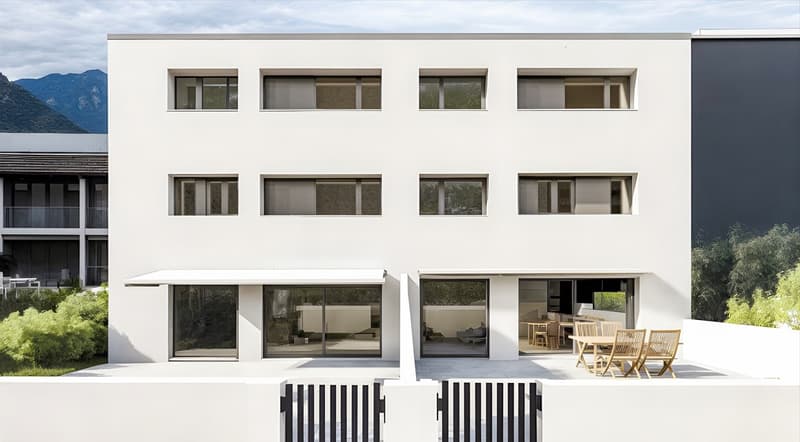 3-story modern apartment building with large windows, balconies, and a patio area with outdoor furniture