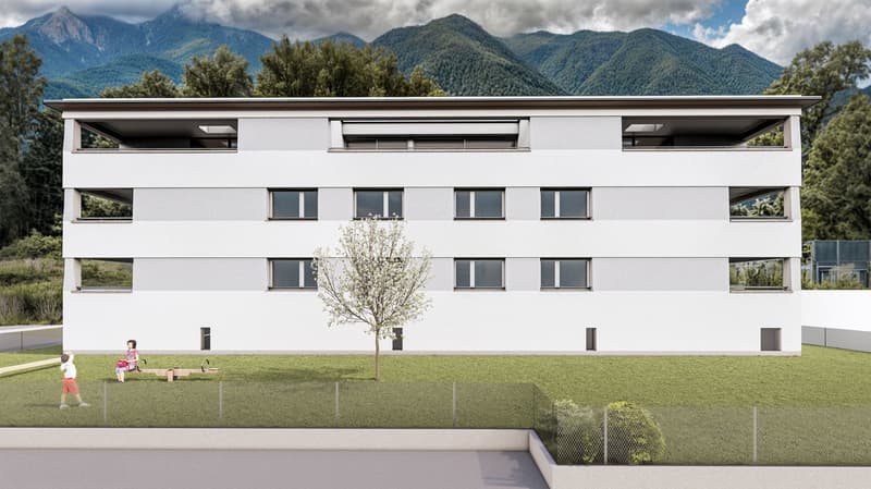 Modern, white, multi-story building with multiple windows, a grassy lawn in front, a bench for children, a tree, and mountains in the background.