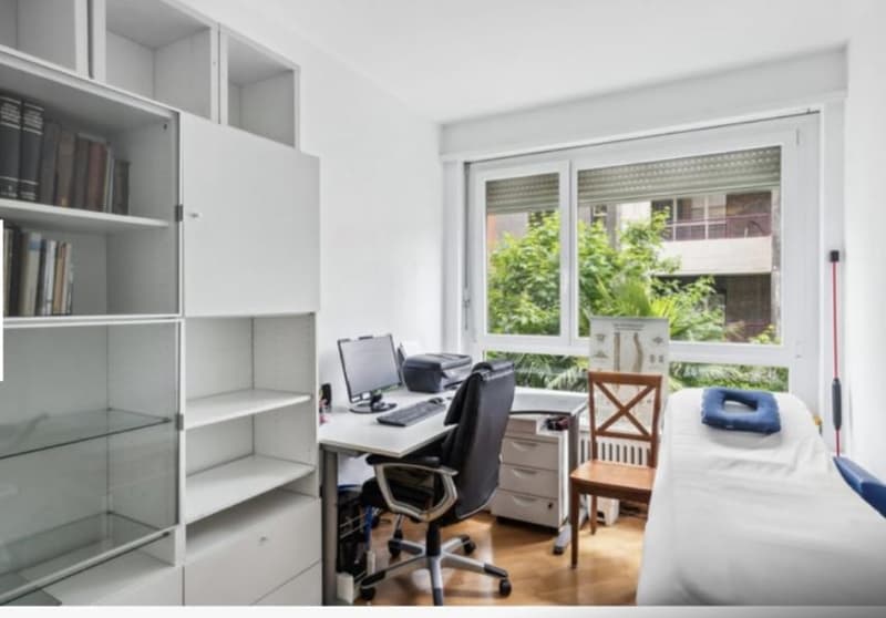 Desk with computer and chair, a bed, bookshelf, and wooden chair