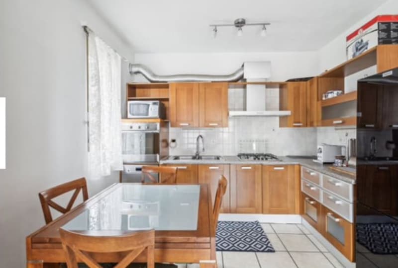modern kitchen with wooden cabinets, tiled floor, dining table with chairs, microwave, oven, and sink