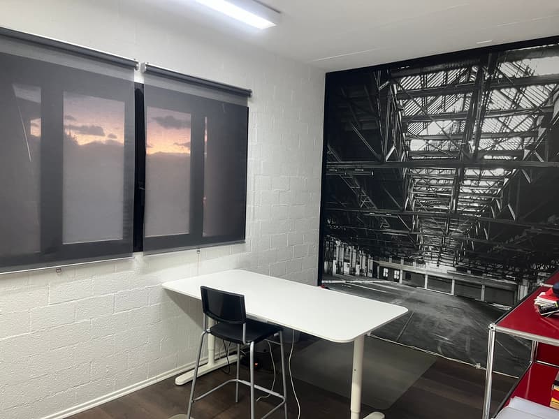 modern office room, white desk, gray chair, black shades, white wall, mural