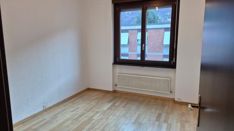 empty room, wooden floor, white walls, large window, heater