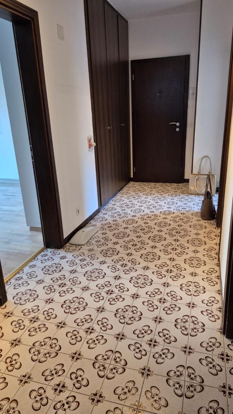 Wooden doors, white and brown tiled floor, white walls, power outlet on the wall