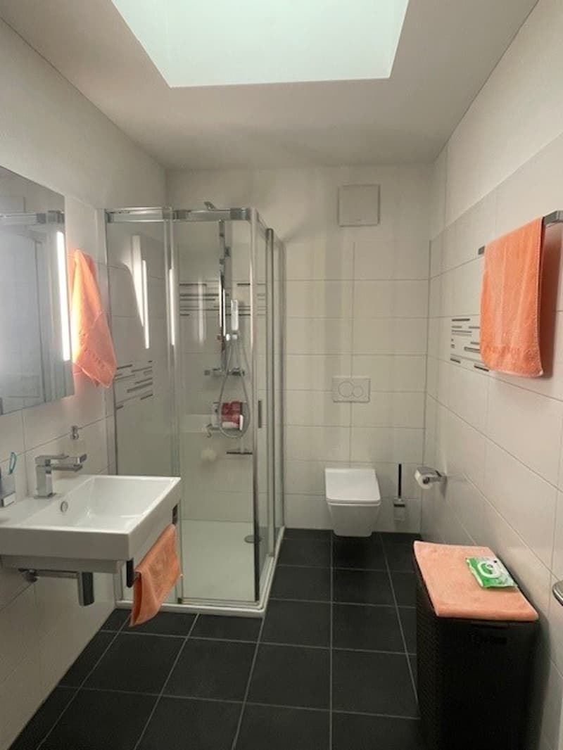 tiled floor, shower stall, sink, toilet, two towels, soap, toilet paper