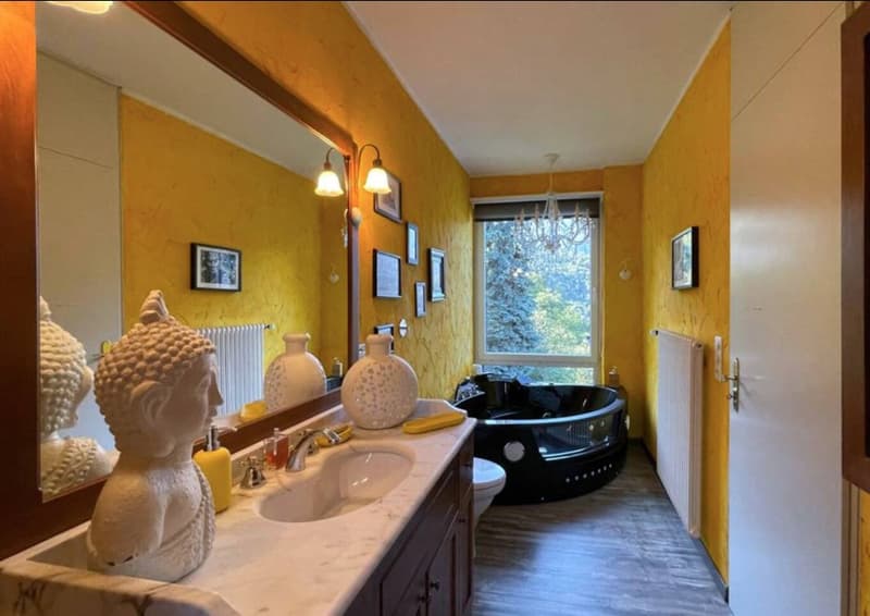yellow wall, marble sink, mirror, large windows, jacuzzi, toilet, radiator