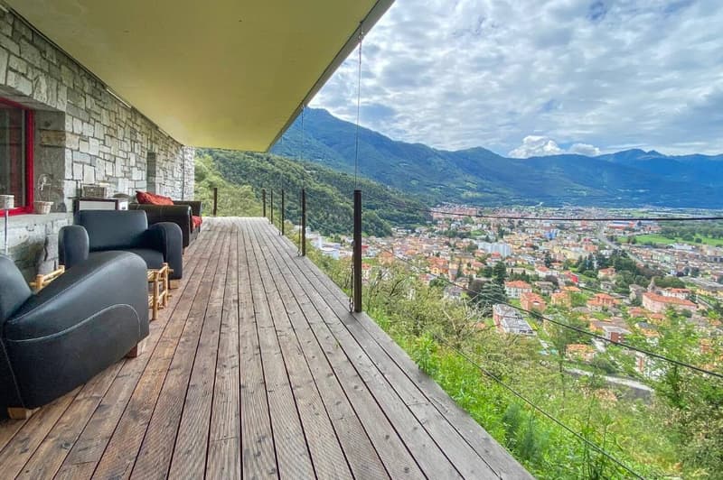 Wooden deck, modern chairs, scenic valley view, mountain backdrop
