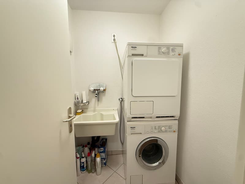 Small room with a sink, washing machine, and dryer
