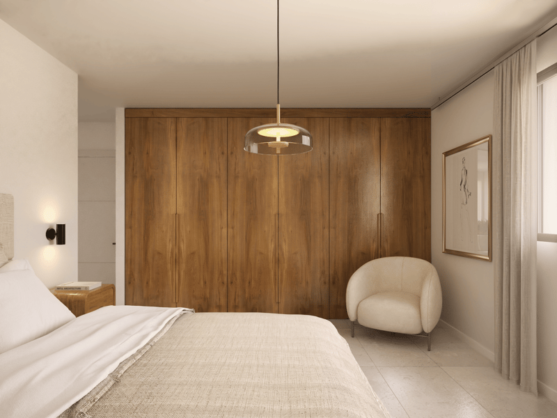 A bedroom with a bed, a chair, a nightstand, a wooden wall, a ceiling lamp, and a picture frame.