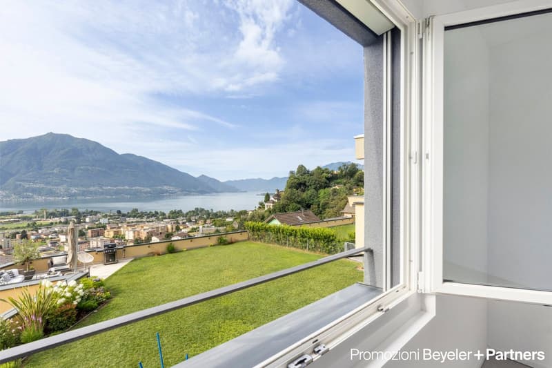 Balcony with railings overlooking mountain, lake, and town