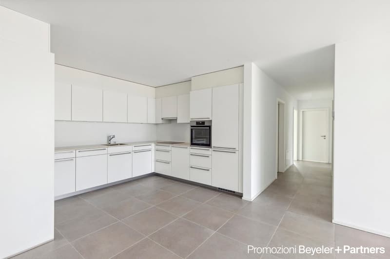 Fully fitted modern kitchen with tiled floor, white cabinets, granite countertop, stainless steel sink and faucet, built-in oven and dishwasher