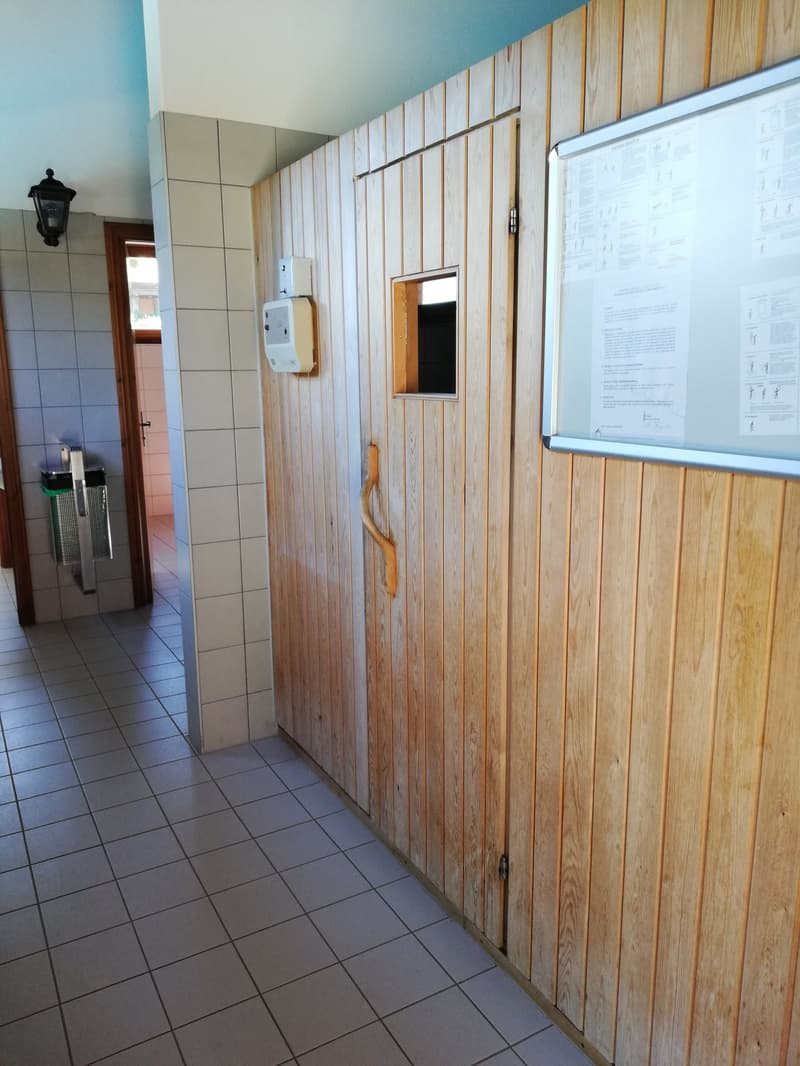 Tiled floor, wooden paneled walls, storage cabinets, and a washing machine visible