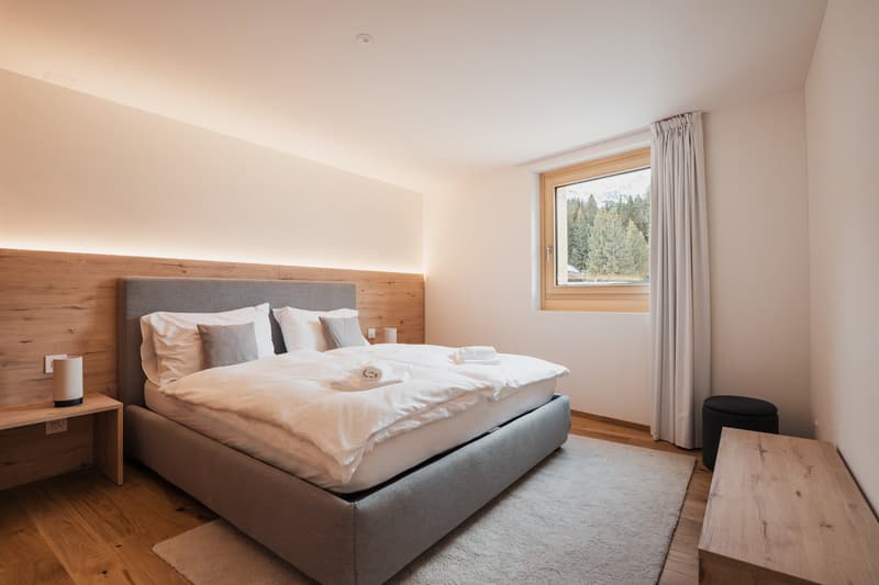 double bed, two side tables, one with lamp, carpet, curtains, view outside