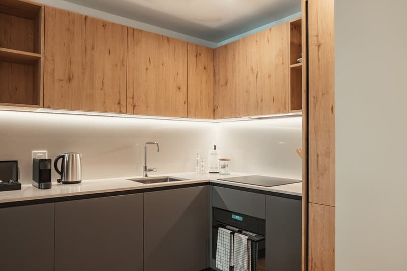 Modern kitchen with wooden cabinets, white countertops, stainless steel sink, and built-in appliances.