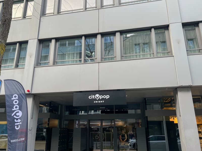 The image shows a multi-story commercial building with a large glass facade. The building has the 'Citypop 2night' logo displayed prominently on the front entrance. The building appears to be a modern, commercial structure with a sleek, minimalist design.