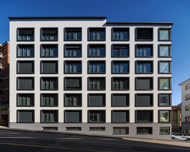 Multi-storey residential building, modern design, white facade, multiple large windows, modern architecture