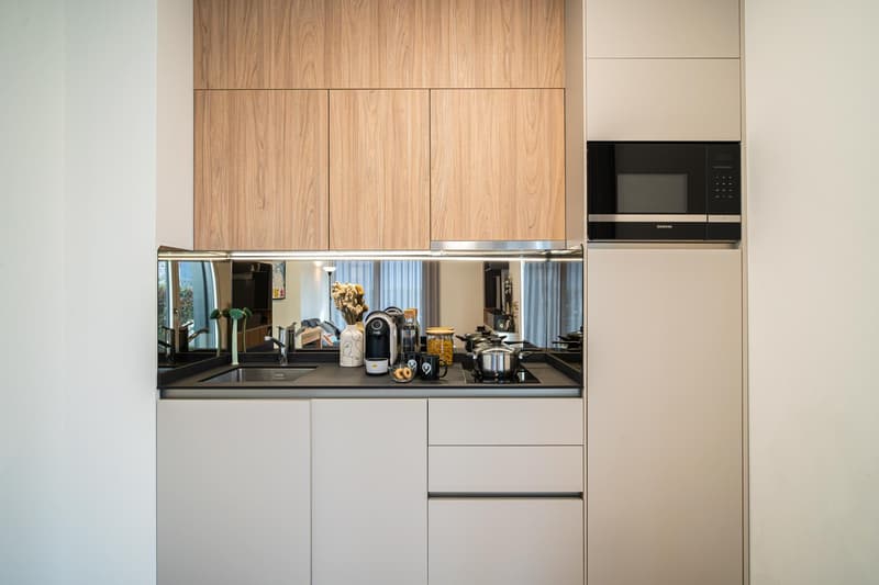 contemporary kitchen with modern cabinets, granite countertop, integrated appliances, ample storage, sleek stainless steel elements, and a microwave oven