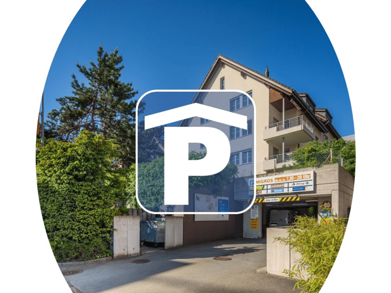 A multistory residential building with garage parking, entrance at street level, small entrance passage with plants and greenery.