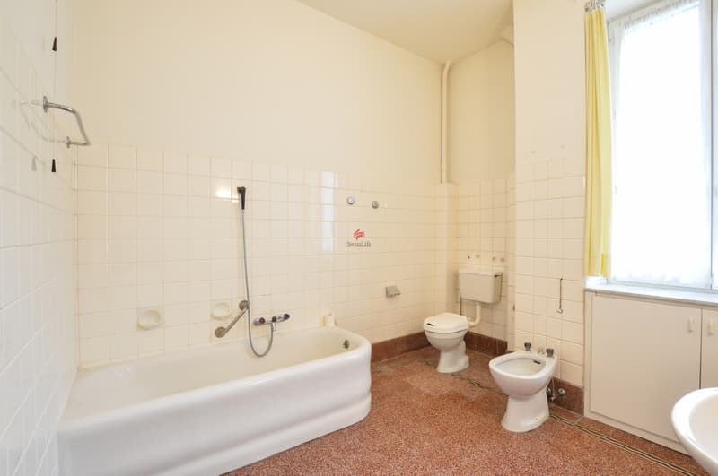 Das grosszügige Badezimmer im ersten Stockwerk verfügt über eine Badewanne, ein Lavabo, ein Bidet und ein WC. / Il spazioso bagno principale al primo piano con vasca da bagno, lavabo, bidet e WC di
