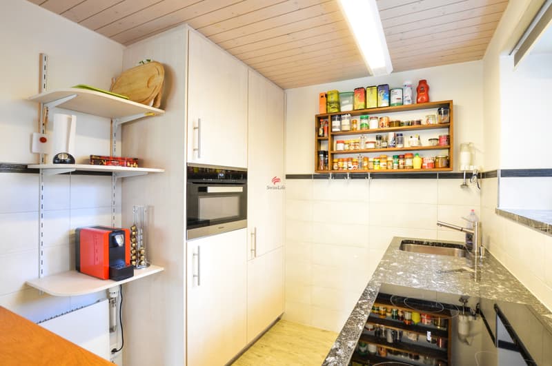 In der Küche mit Tageslicht gibt es genügend Arbeitsfläche, einen Kühlschrank, einen Backofen etc.
