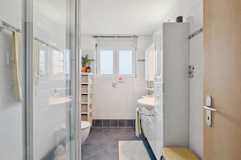 In der zweiten Nasszelle im Obergeschoss befinden sich eine großzügige Dusche, eine Toilette und ein Lavabo. / Nella seconda zona bagno al piano superiore si trovano una spaziosa doccia, WC e lavabo