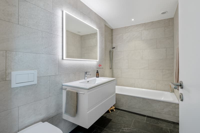 Modernes Badezimmer mit integrierter Badewanne, im gleichen edlen Design