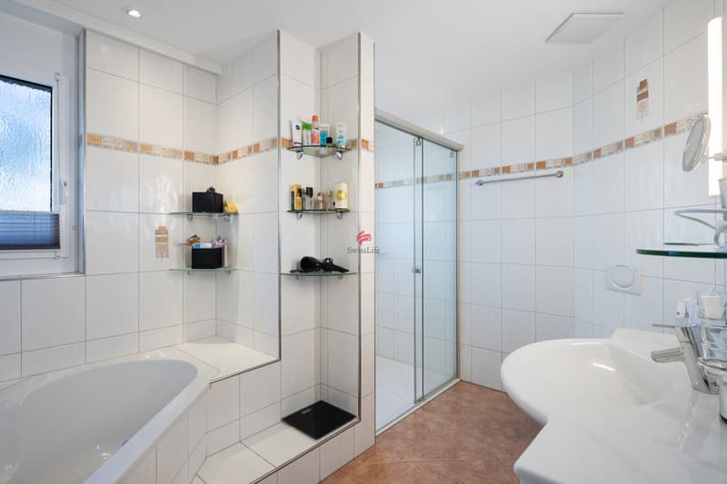 Wellness für zuhause: Grosszügiges Bad mit Tageslicht, Eckbadewanne und Dusche.