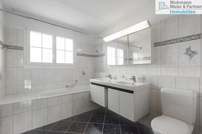 Badezimmer im Obergeschoss mit Doppel-Lavabo, Badewanne, WC und Tageslicht