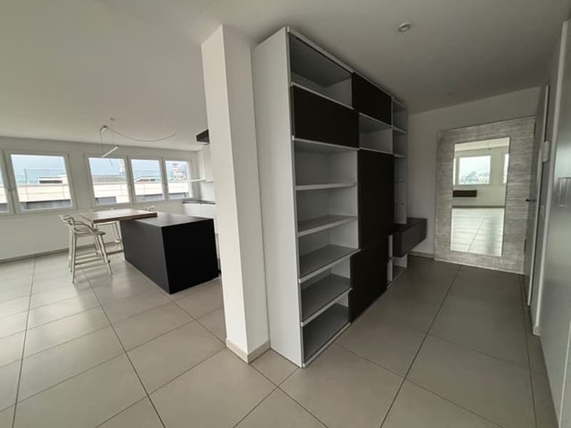 Open concept kitchen-dining area with modern cabinets, neutral color palette, ample windows with city views