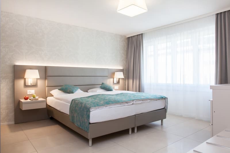 double bed, night tables, side lamps, electrical outlets, windows, curtains