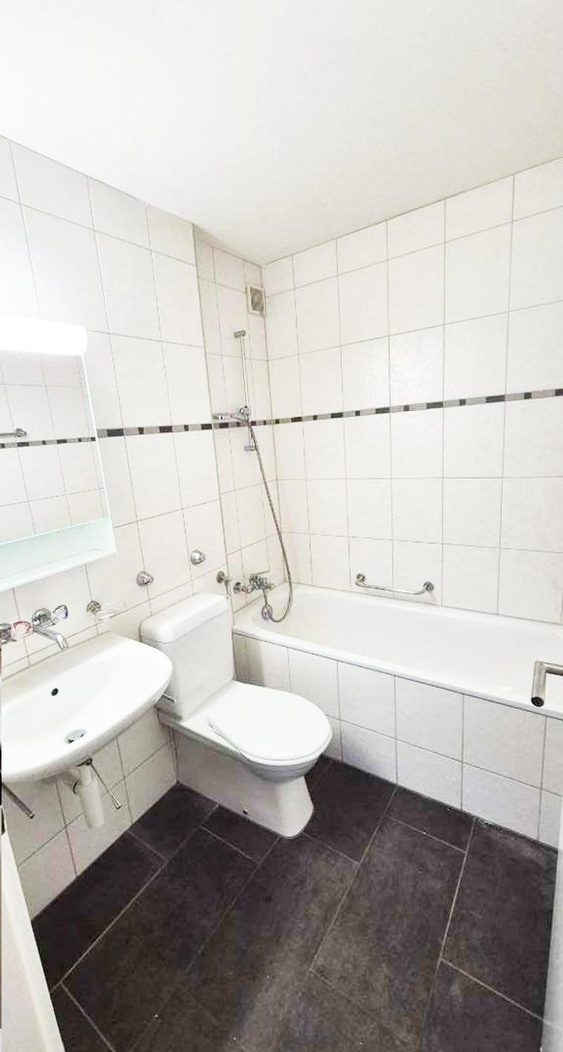 modern design, bathtub, toilet, sink, mirror, tiled walls, black tiled flooring