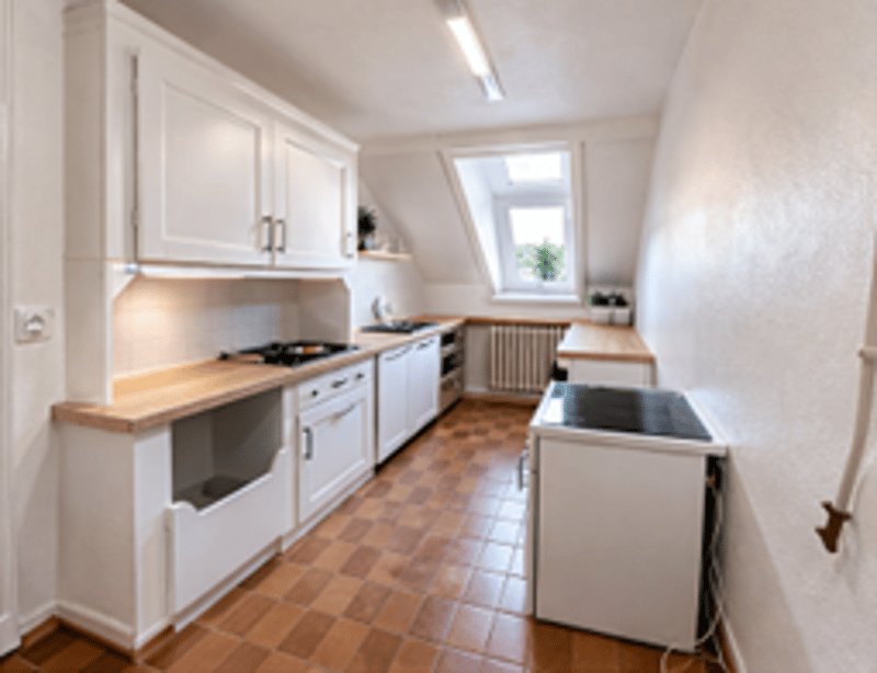 modern kitchen with white cabinets, wooden countertops, tiled floor, gas stove, sink, window, skylight
