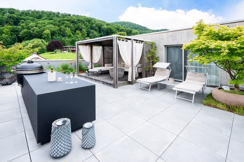 Outdoor area with a patio, a canopy, a grill, lounge chairs, a table, and a view of the mountains.