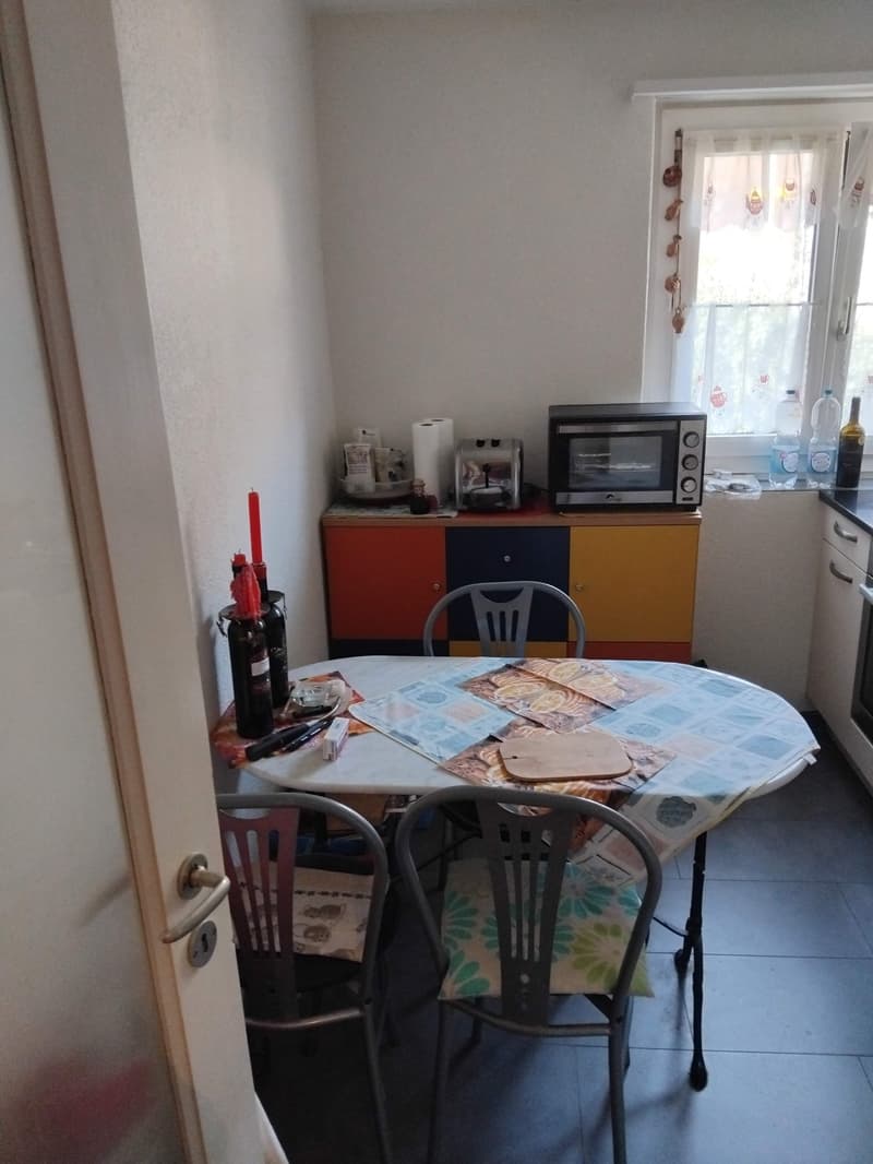 Dining room with a table, chairs, and a cabinet with a microwave and toaster