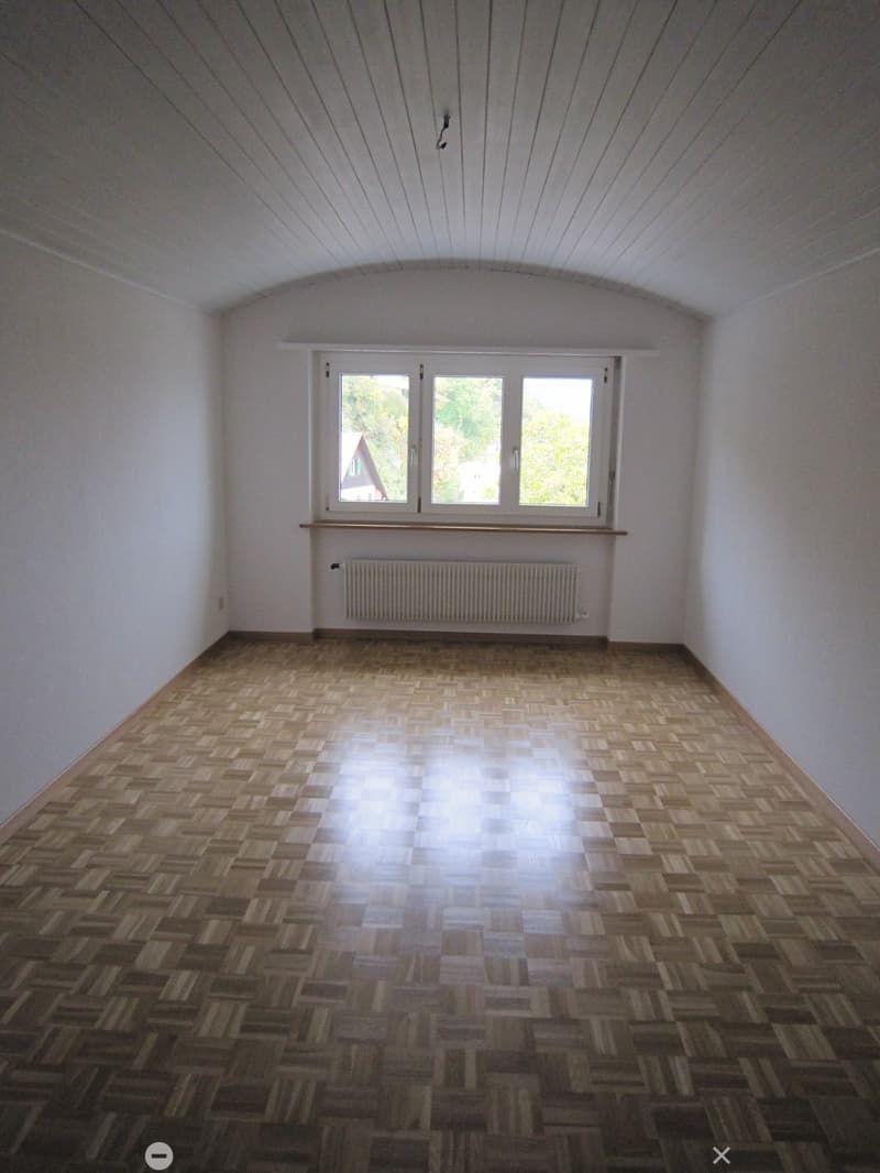 empty room, wooden parquet floor, white walls, large window, white radiator