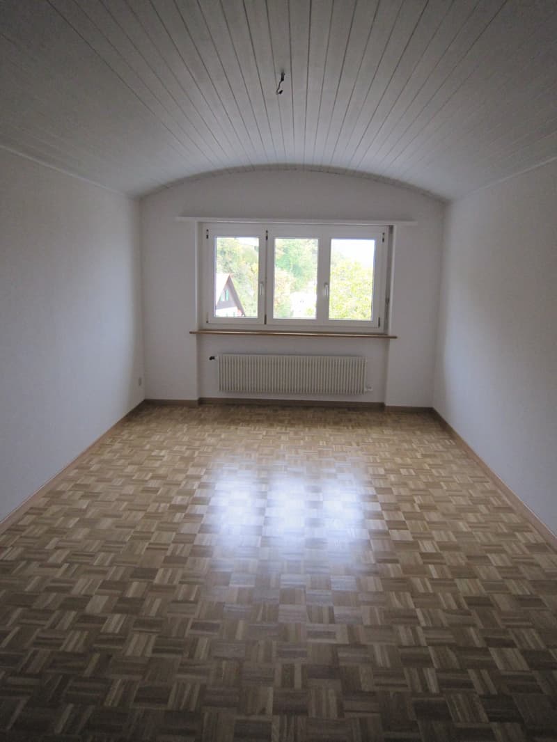 empty room, wooden parquet floor, white walls, large window, white radiator