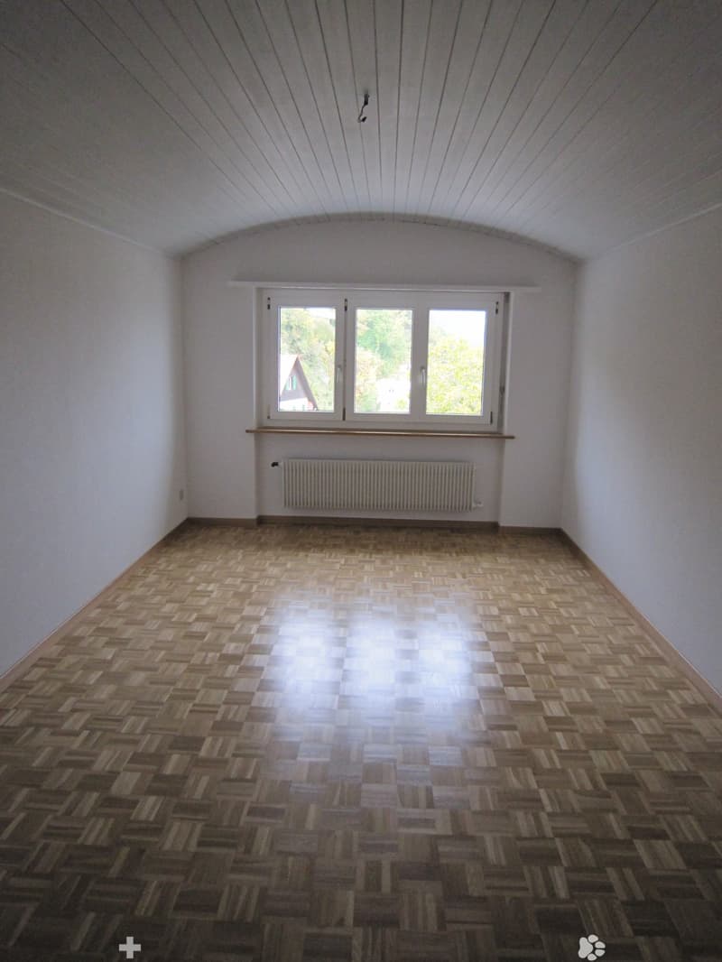 empty room, wooden parquet floor, white walls, large window, white radiator