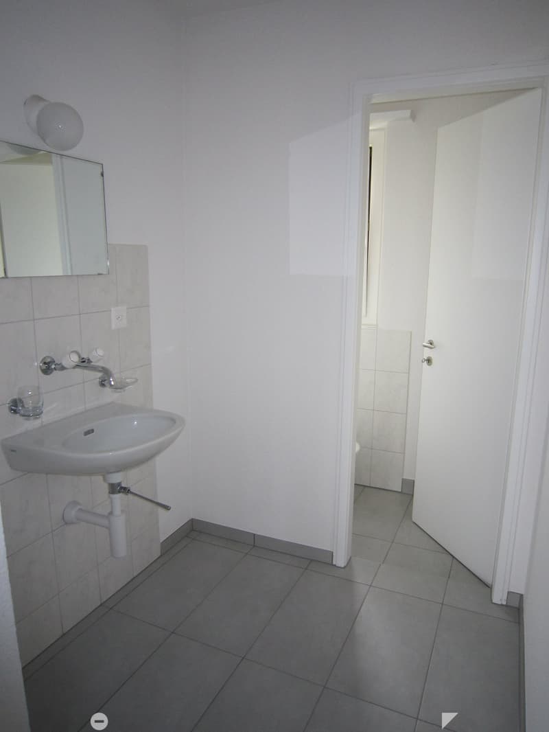 Bathroom with white sink, mirror, and tiled floor