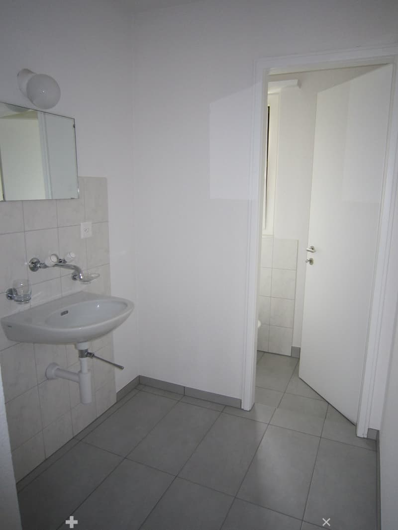 Bathroom with white sink, mirror, and tiled floor