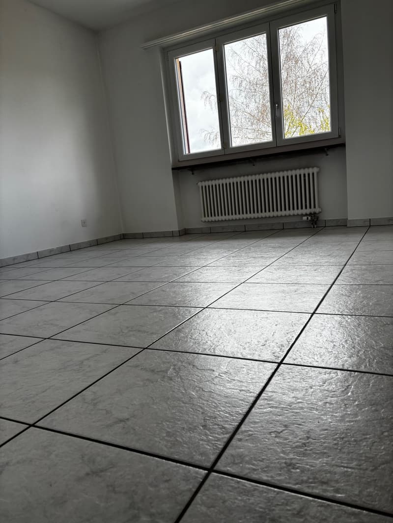 empty room, white walls, tiled floor, large window, white radiator