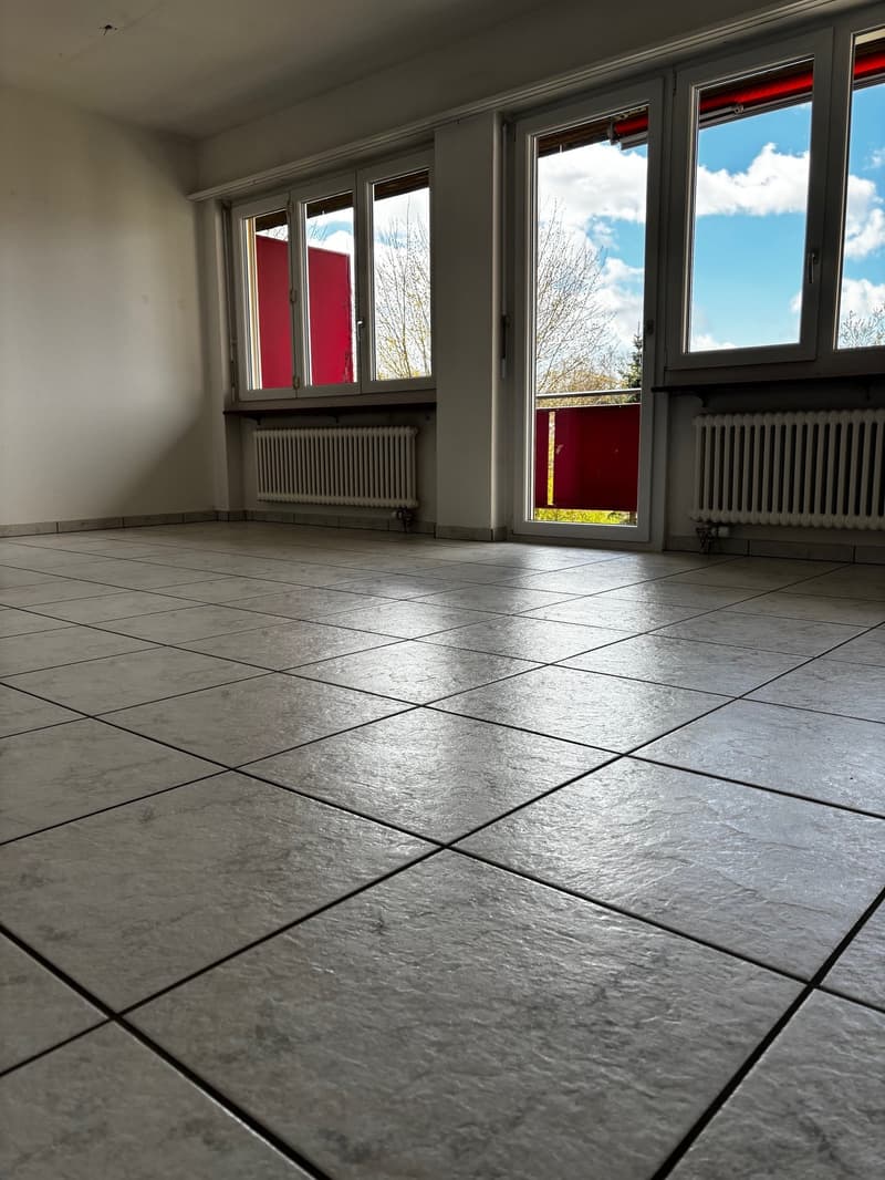 empty room, white walls, white tile floor, large windows, balcony