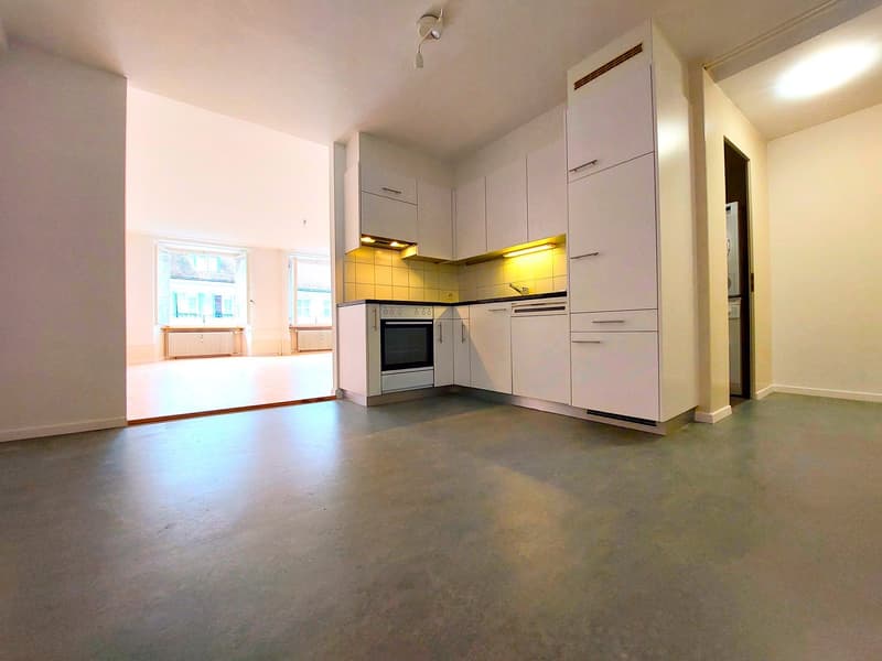 Kitchen room with a kitchen island, underfloor heating, large windows, and windows leading to the hallway.