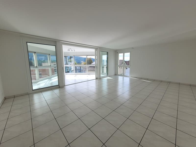 white tile floor, glass doors to balcony, large windows